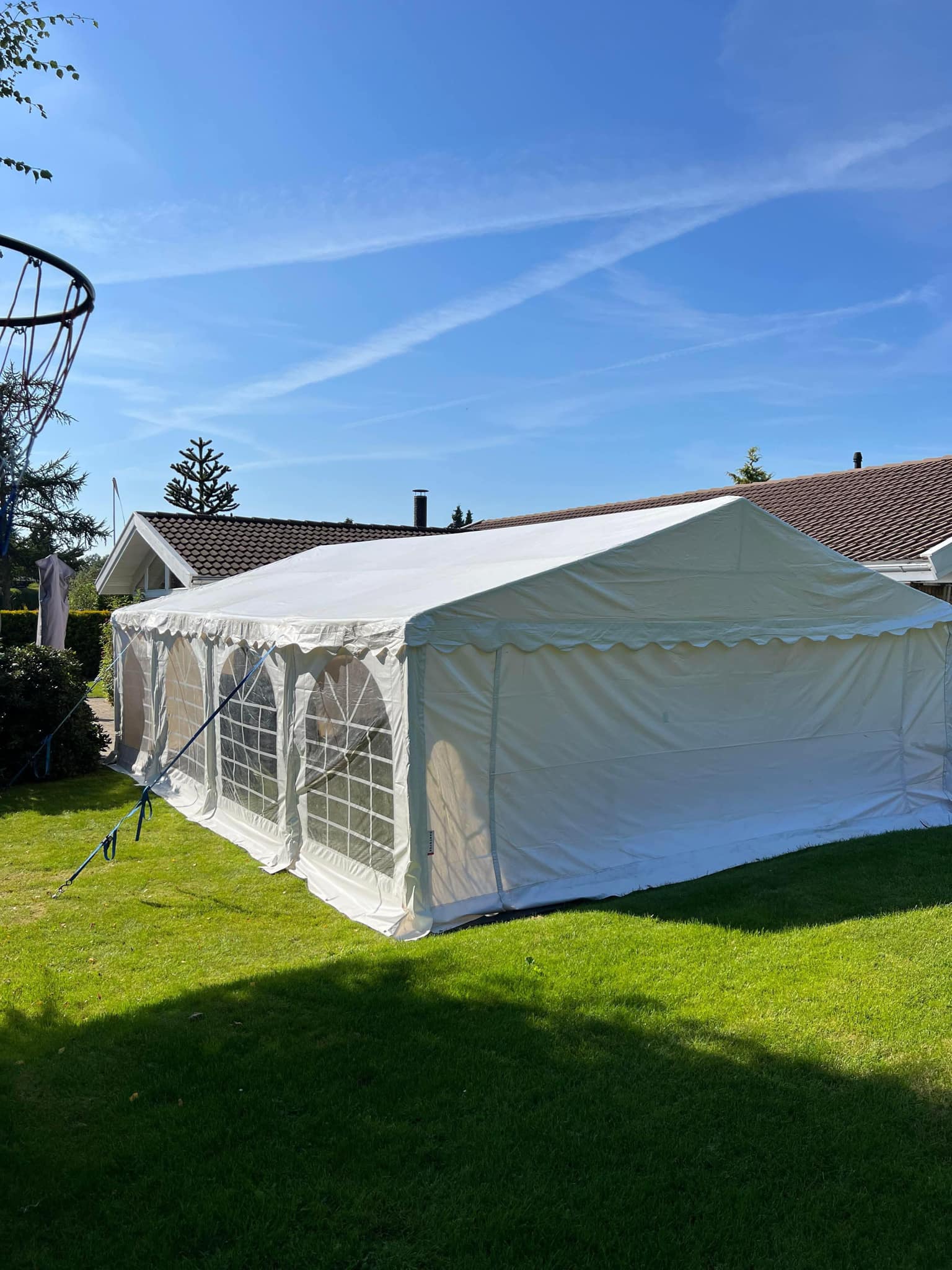 Eight shirts arranged on table in black, olive, grey, blue, white, red, mustard, and green.