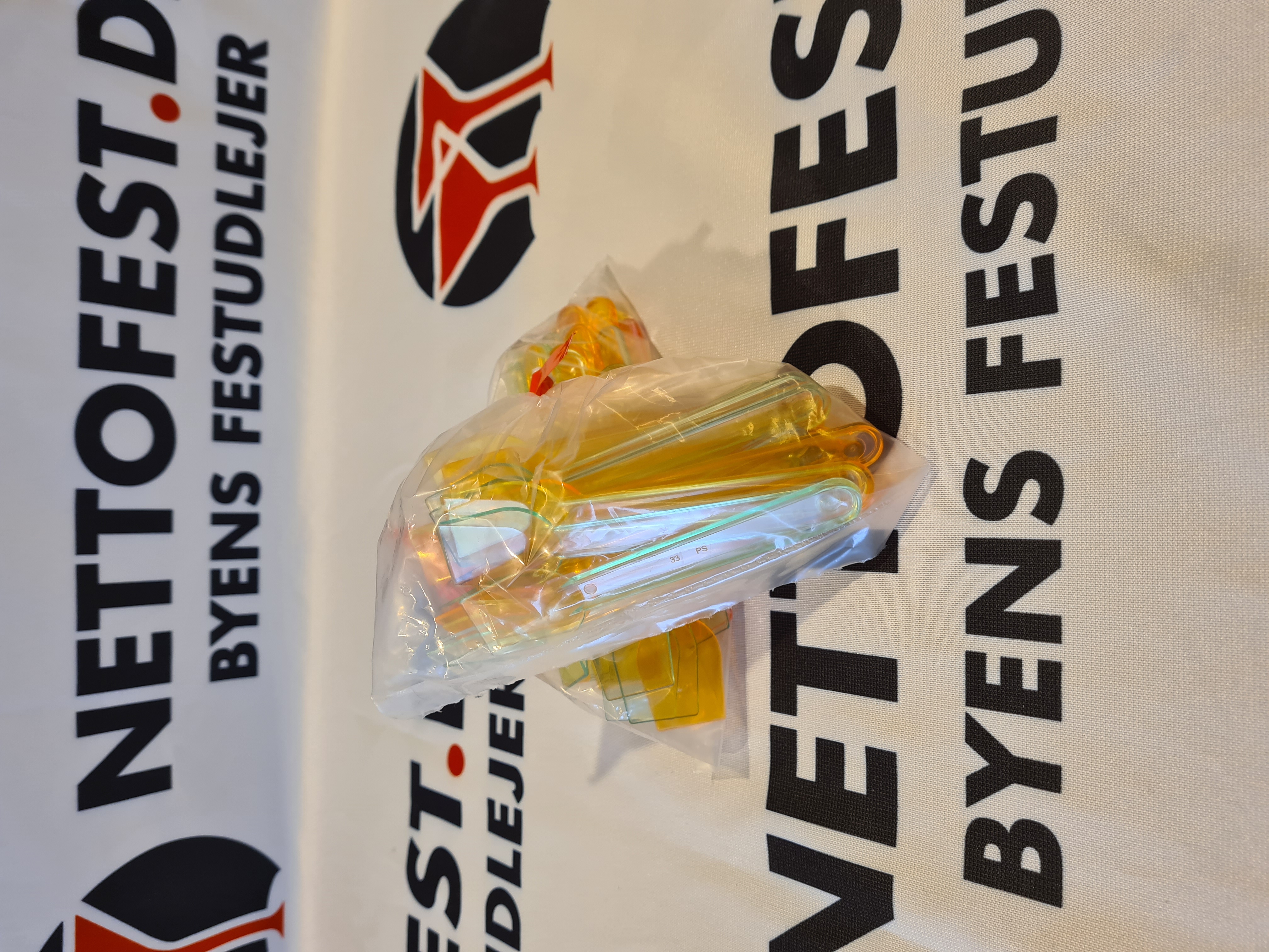 Eight shirts arranged on table in black, olive, grey, blue, white, red, mustard, and green.