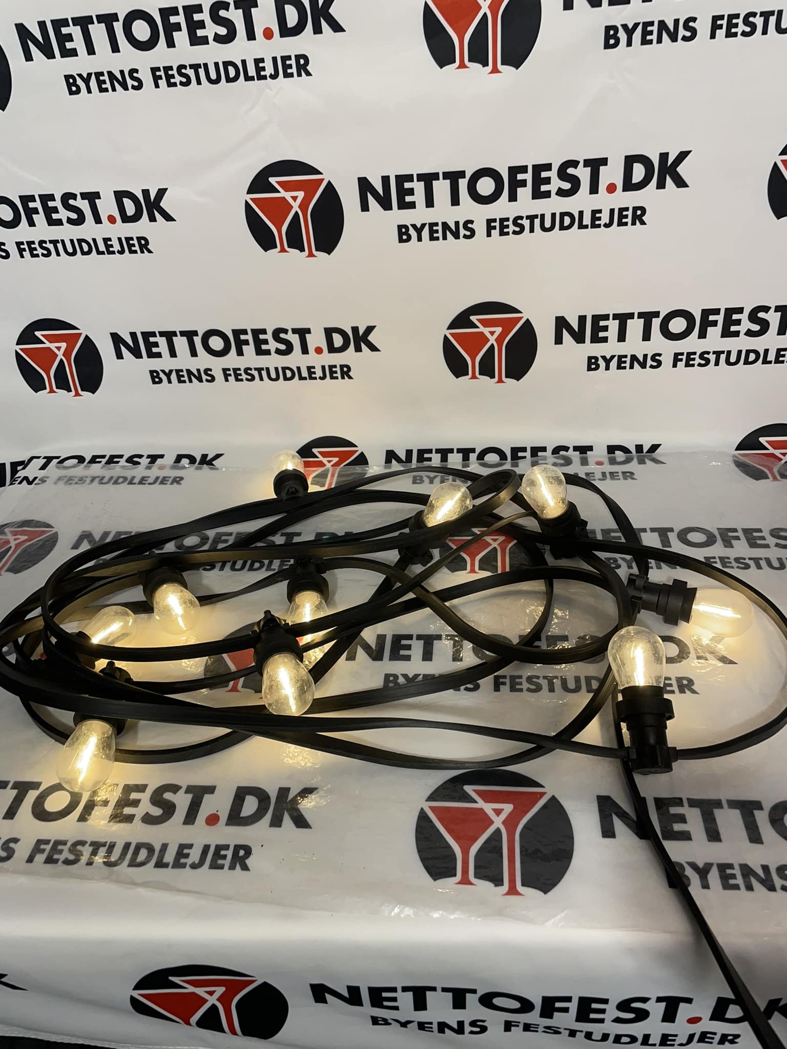 Eight shirts arranged on table in black, olive, grey, blue, white, red, mustard, and green.