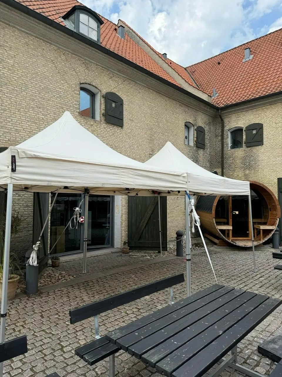 Eight shirts arranged on table in black, olive, grey, blue, white, red, mustard, and green.