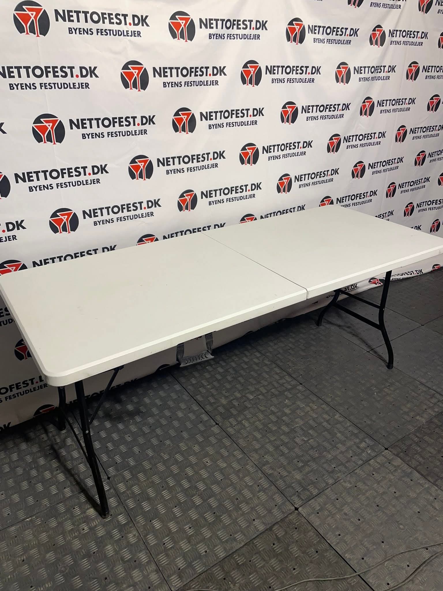 Eight shirts arranged on table in black, olive, grey, blue, white, red, mustard, and green.