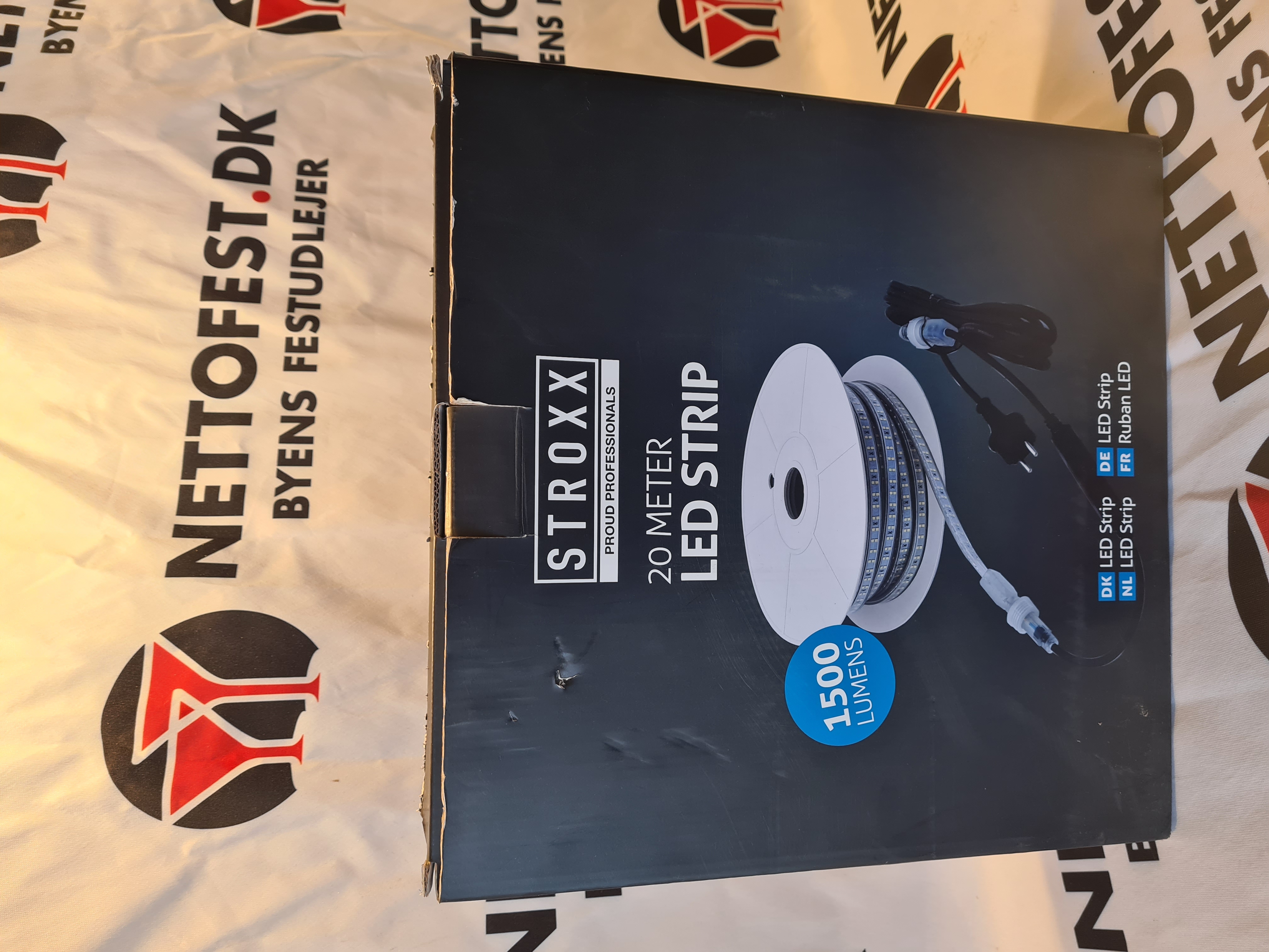 Eight shirts arranged on table in black, olive, grey, blue, white, red, mustard, and green.