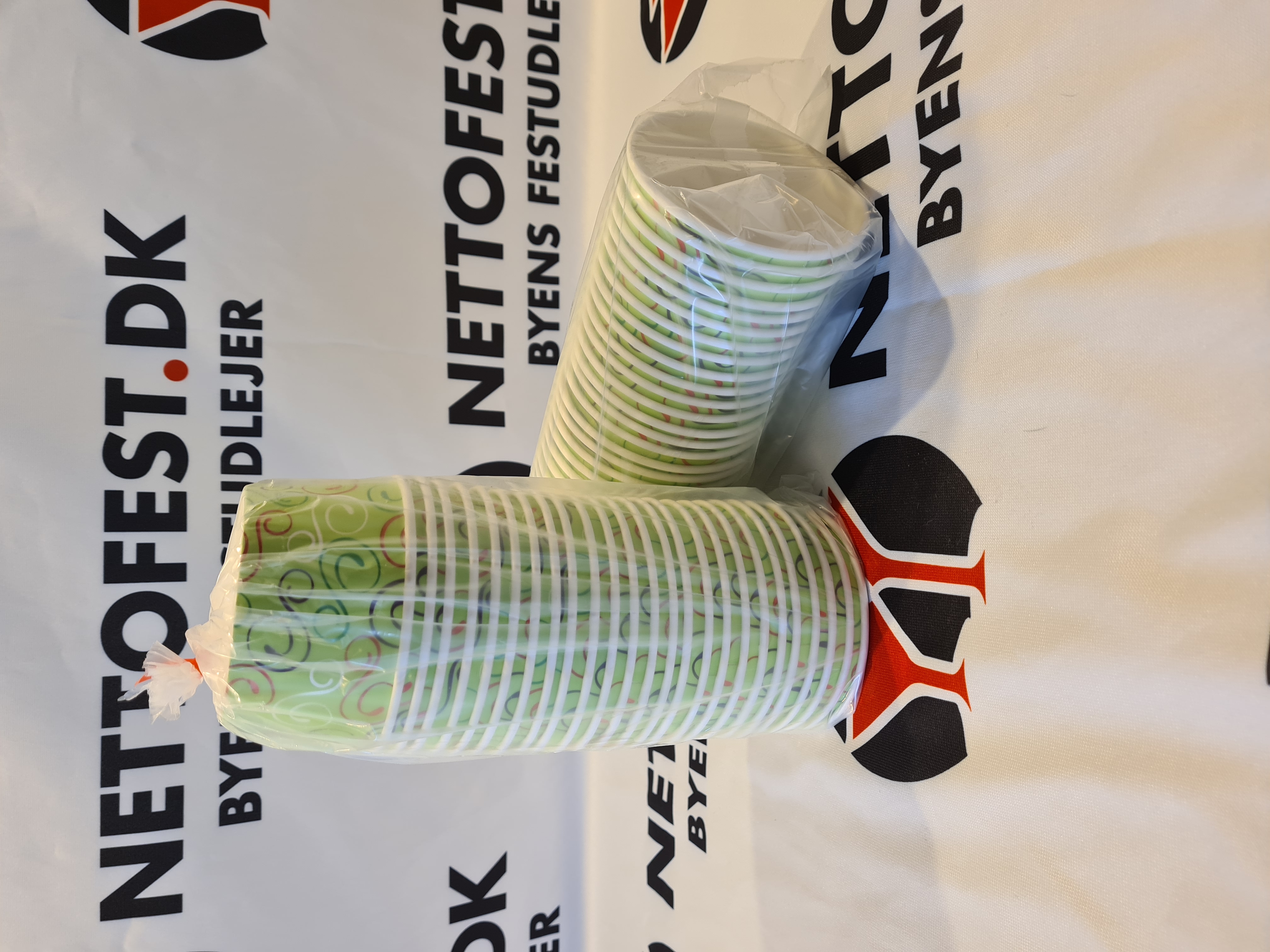 Eight shirts arranged on table in black, olive, grey, blue, white, red, mustard, and green.