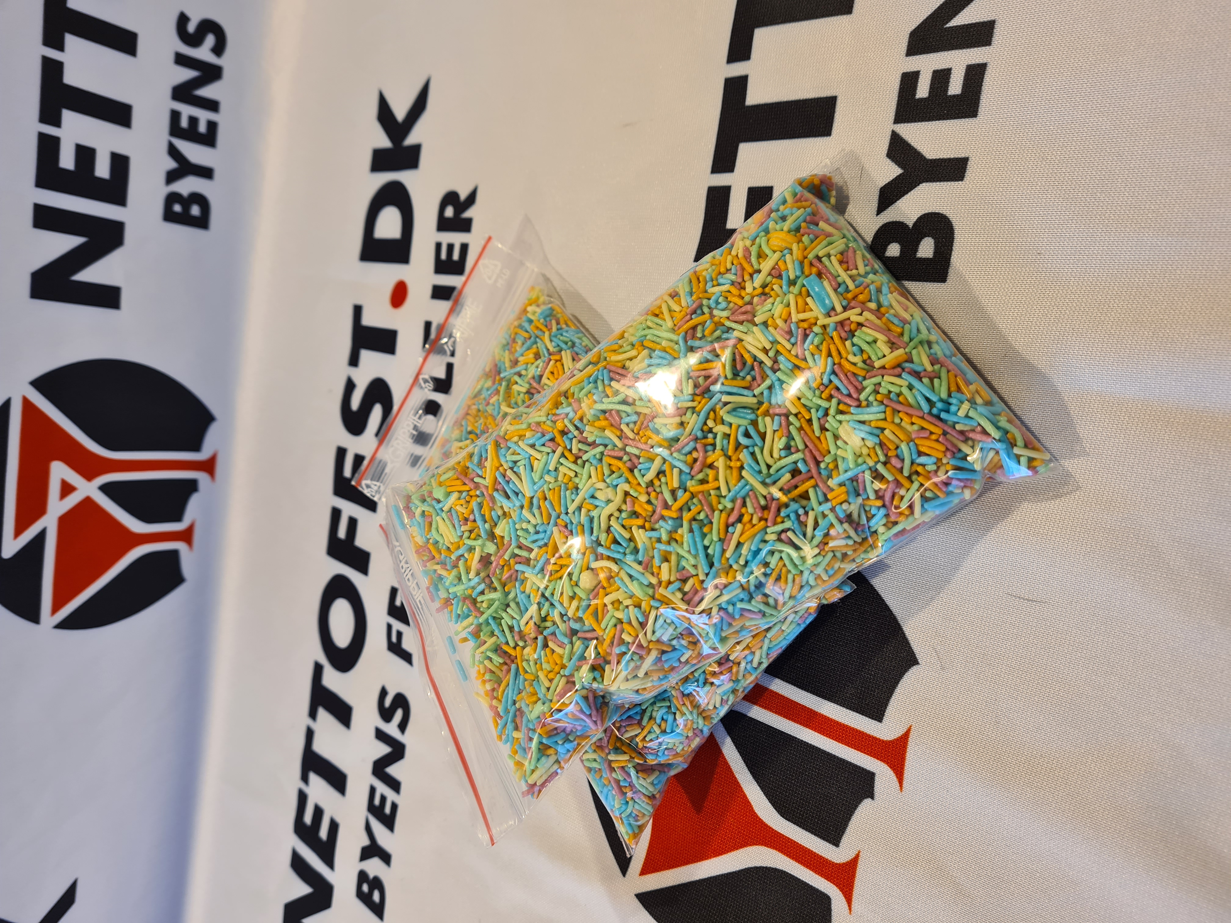 Eight shirts arranged on table in black, olive, grey, blue, white, red, mustard, and green.